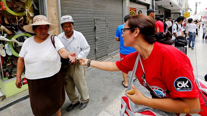 file-photo--a-peruvian-ministry-of-health-worker-hands-out-condoms-to-a-couple-on-international-condom-day-in-downtown-lima-1.jpg