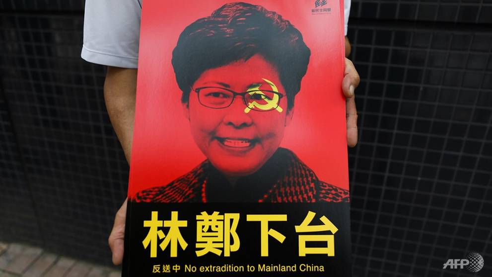 a-protester-holds-posters-showing-hong-kong-chief-executive-carrie-lam-before-a-rally.jpg