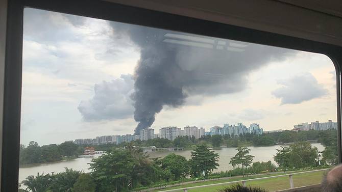 smoke-rising-into-the-sky-as-seen-from-inside-a-train-near-jurong-east-station.jpg