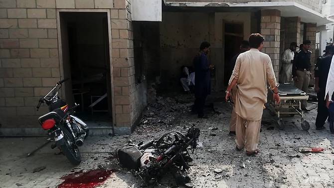 Pakistani security officials examine the site of a suicide bomb attack on Jul 21, 2019