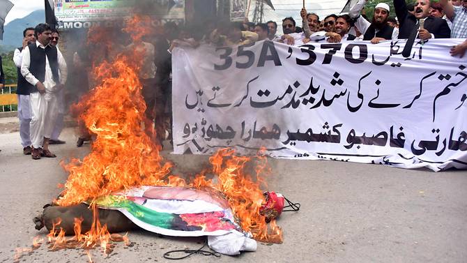 Pakistani Kashmiri lawyers shout slogans beside a burning effigy Aug 7