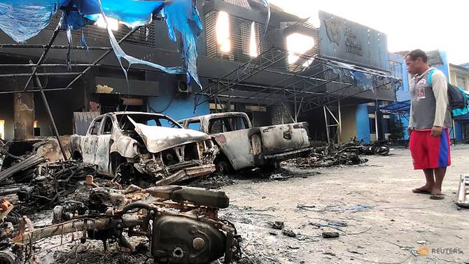 man-looks-at-damaged-vehicles-in-front-of-indonesia-s-customs-and-excise-office-after-a-riot-in-jayapura-1.jpg