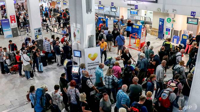 tourists-wait-at-a-thomas-cook-company-counter-at-heraklion-airport-on-the-island-of-crete.jpg