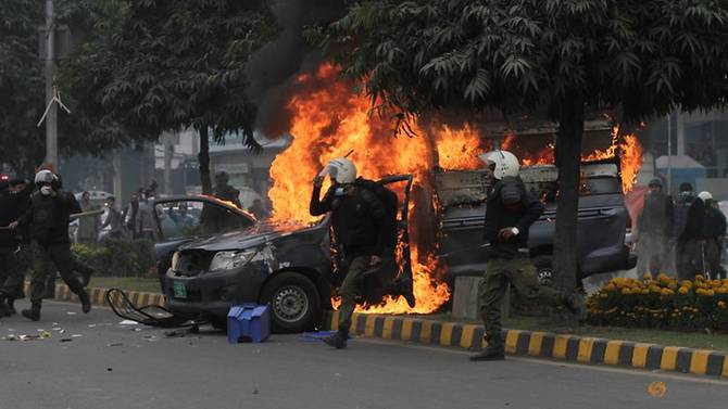 police-officers-run-past-a-vehicle-on-fire-after-a-group-of-lawyers-stormed-the-punjab-institute-of-cardiology-in-lahore--4.jpg
