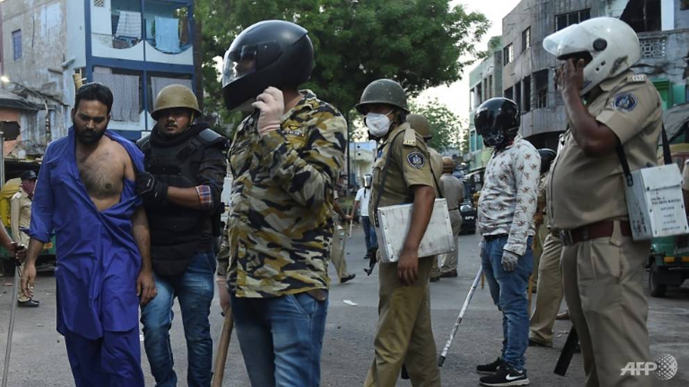 Migrant workers throw stones at police in India in protest against lockdown
