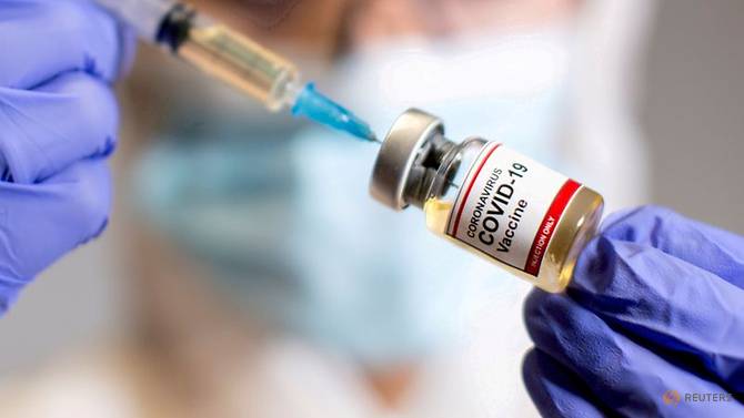 [V2021] Topic officiel File-photo--a-woman-holds-a-medical-syringe-and-a-small-bottle-labelled--quot-coronavirus-covid-19-vaccine-1