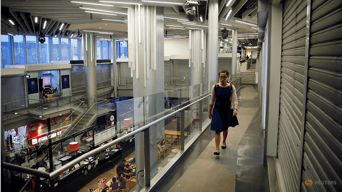 a-woman-passes-closed-down-shops-at-a-section-of-a-mall-in-singapore---2848190--1-.png